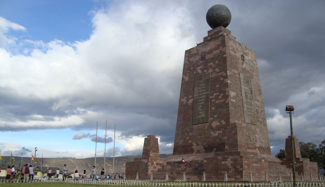 Mitad del Mundo Monument made of brick with globe on top on equator line in Ecuador