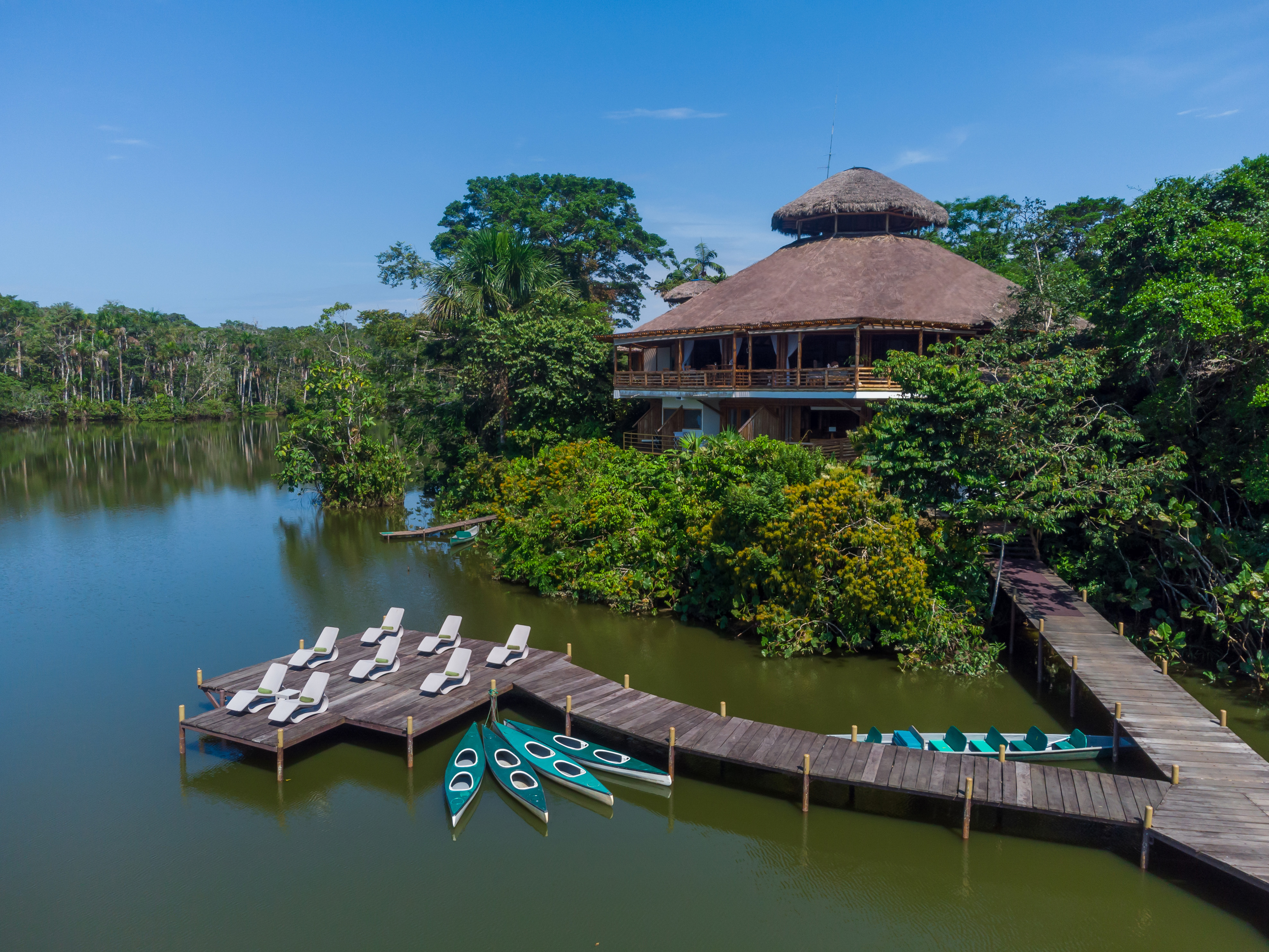 Amazon rainforest cabins reflected in jungle lagoon surrounded by Amazon Rainforest, La Selva Lodge Ecuador