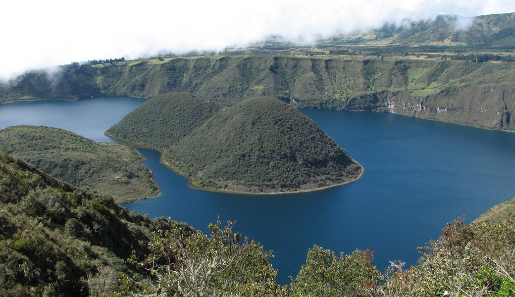 Cuicocha Crater Lake with two volcanic cones in the middle covered in green vegetation, Ecuador