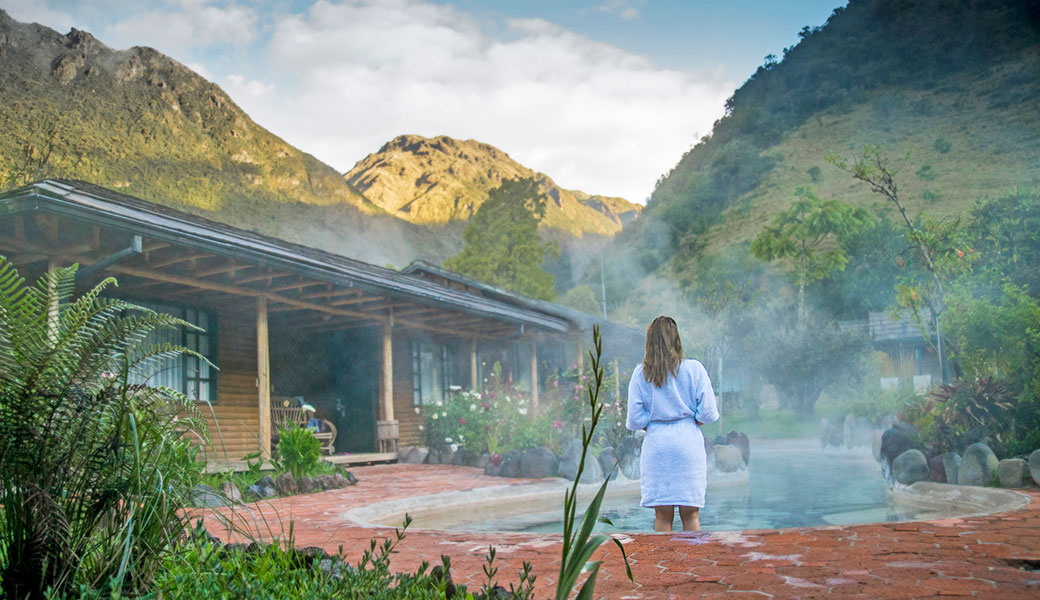 Lady in white robe entering natural thermal pools in Termas Papallacta Ecuador in the Andes Mountains